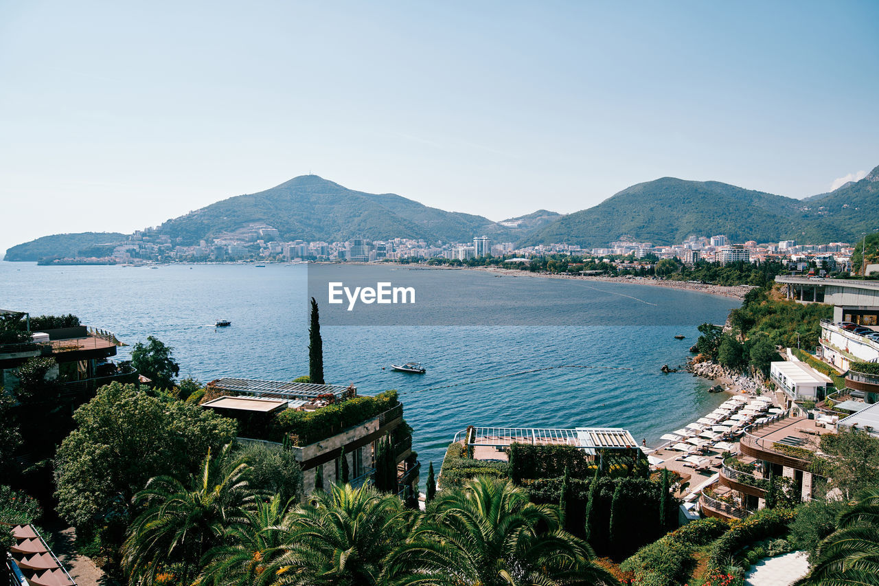 high angle view of townscape by sea against clear sky