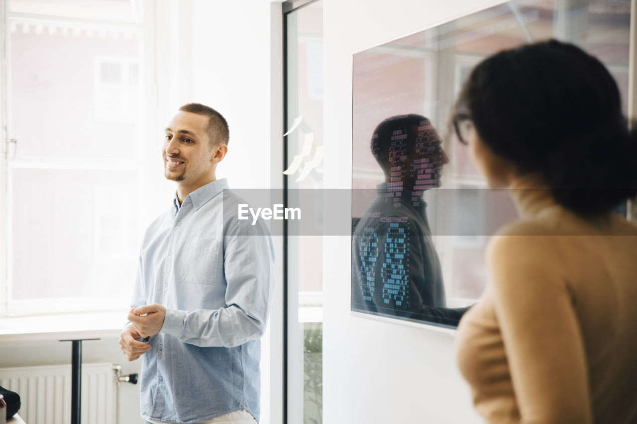 Computer programmers giving presentation over code during meeting