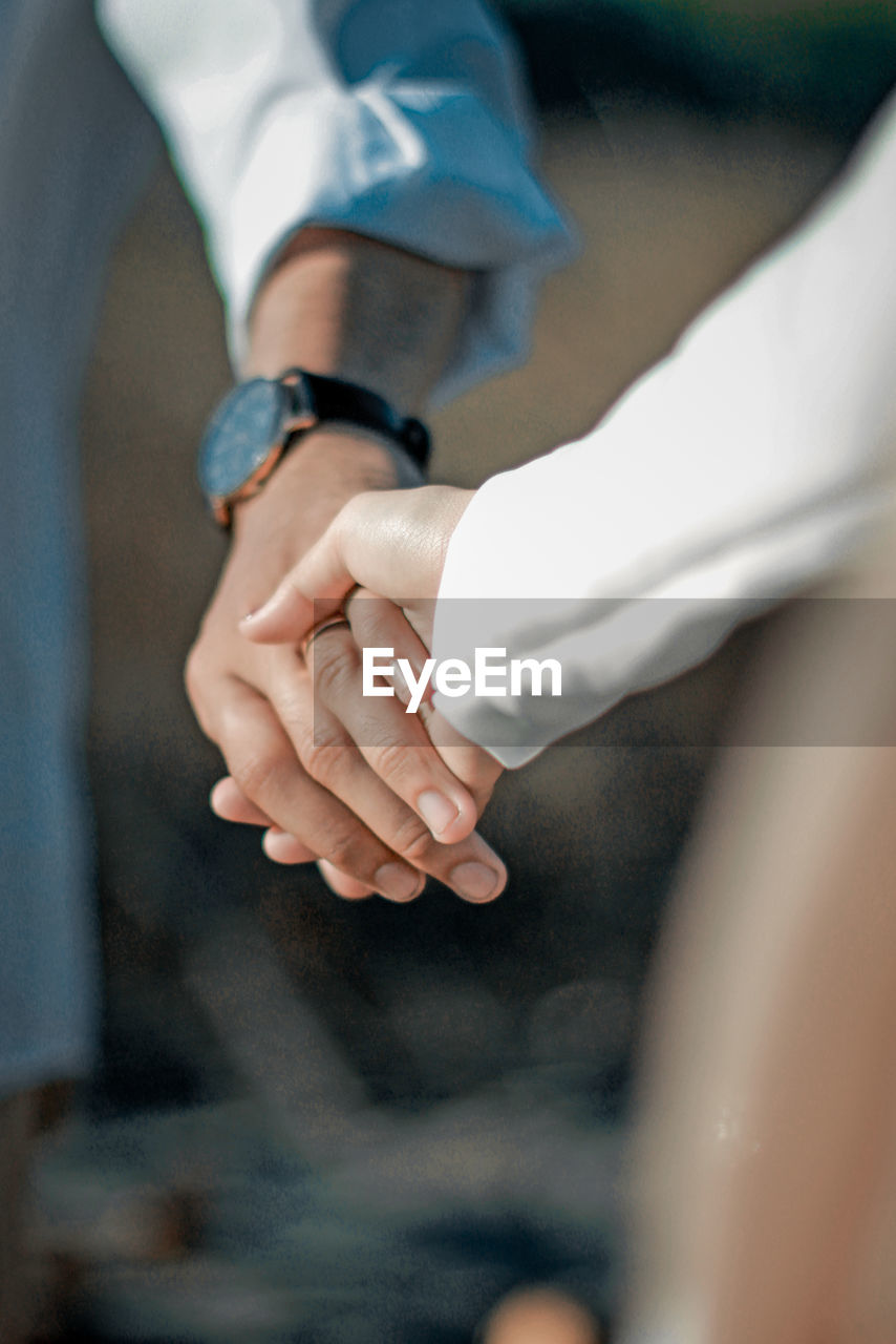 Cropped image of couple holding hands