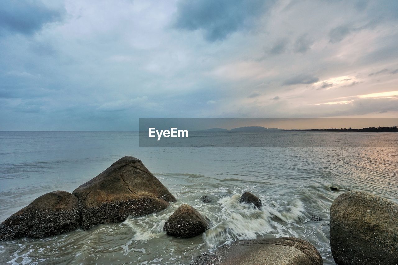 ROCKS IN SEA AGAINST SKY