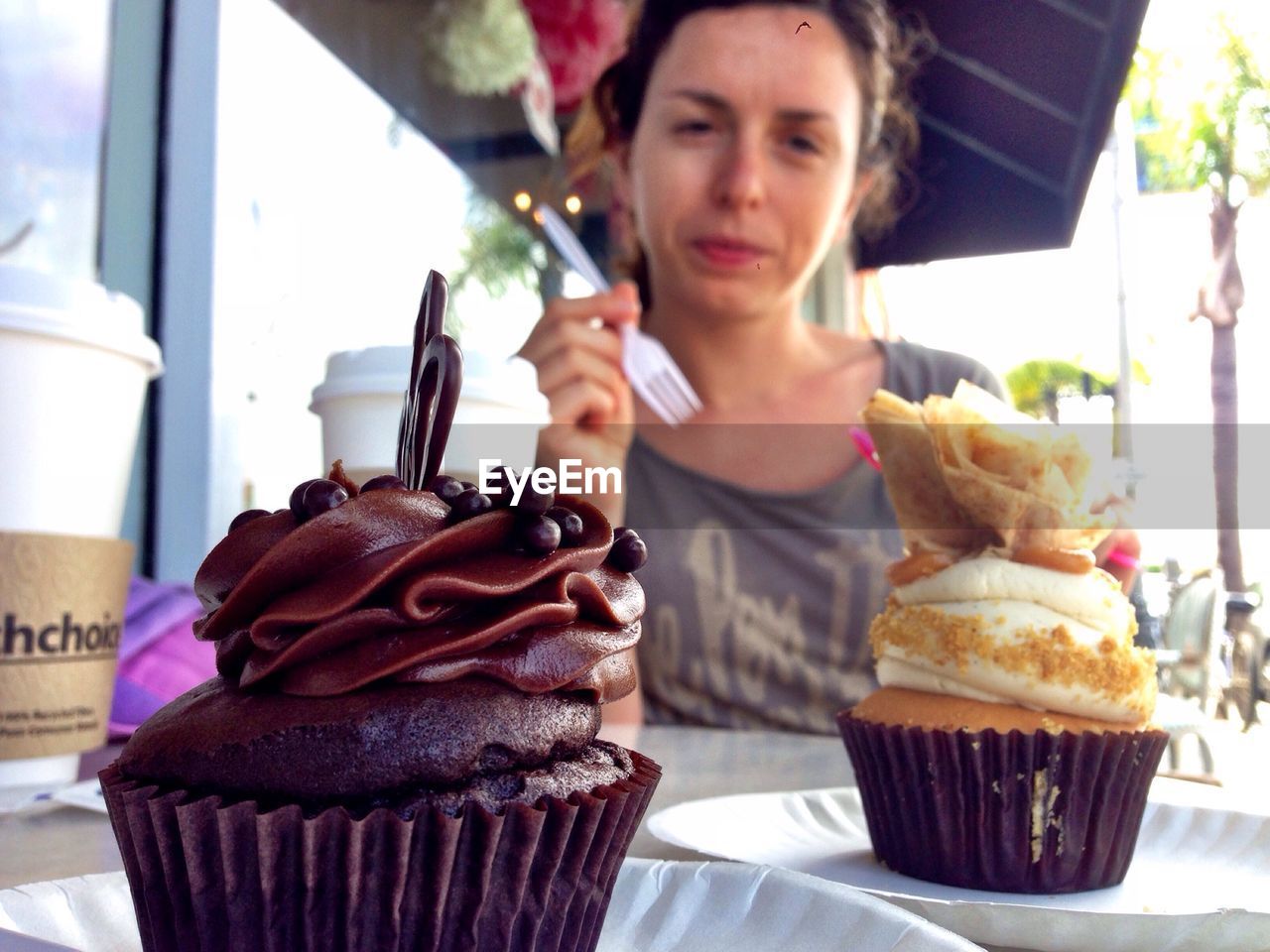 Portrait of woman having cupcakes at outdoor cafe