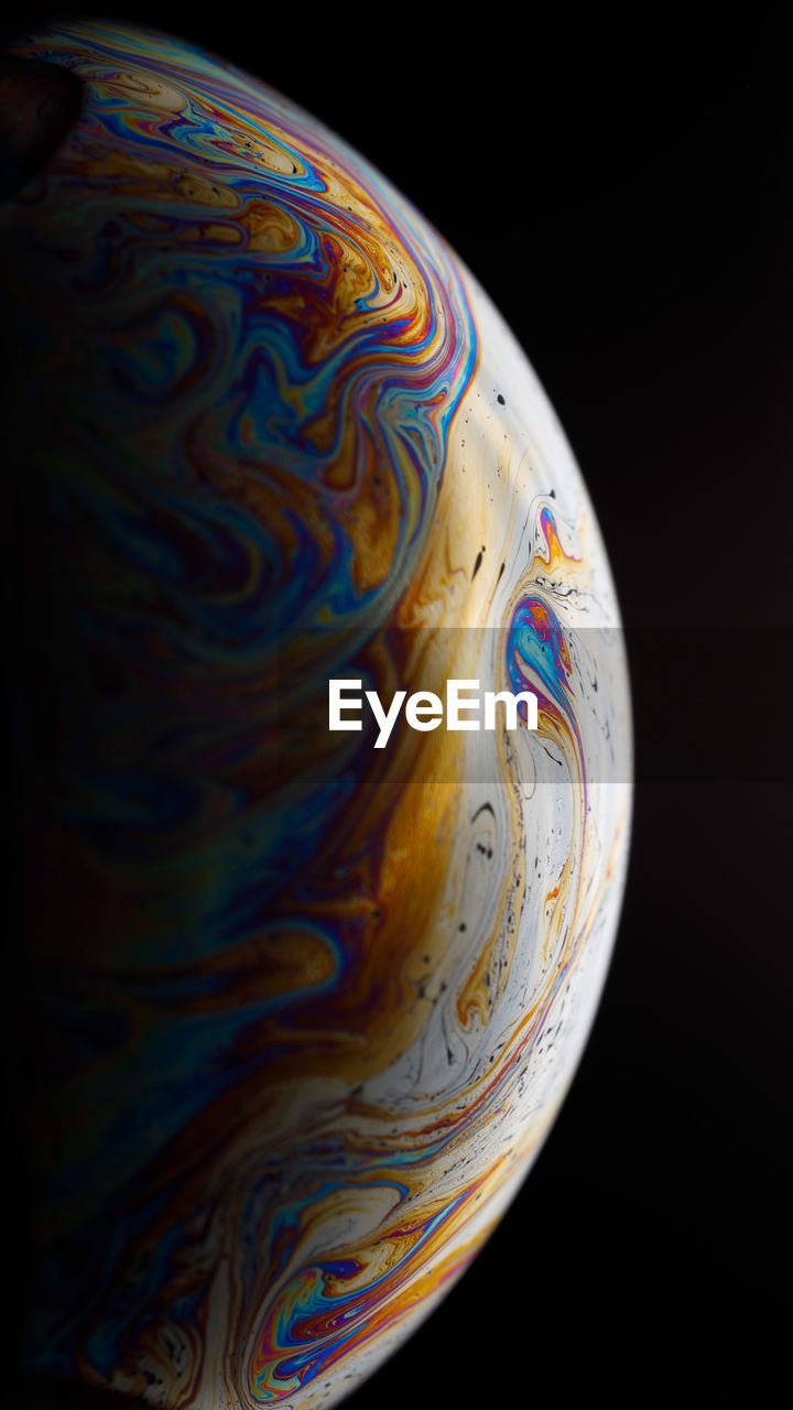 Close-up of multi colored art against black background