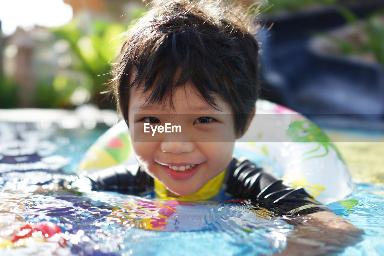 Portrait of happy boy playing in swimming pool