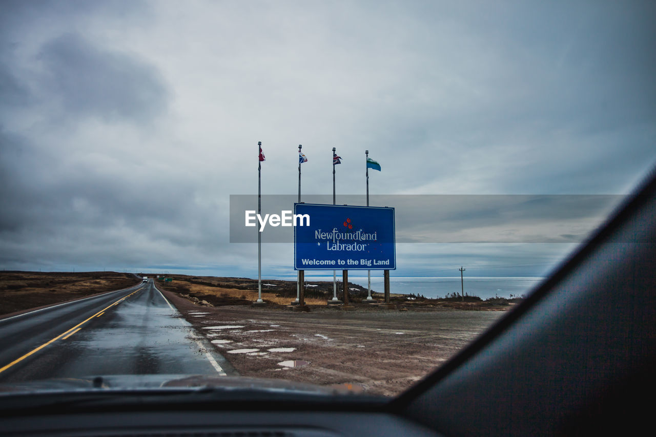 INFORMATION SIGN ON ROAD AGAINST SKY