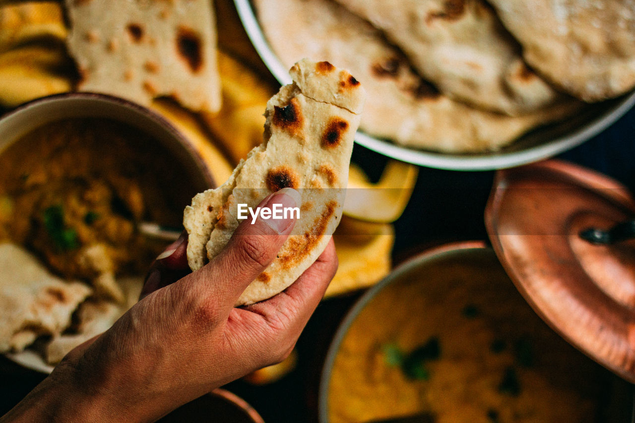 CLOSE-UP OF HAND HOLDING BREAD