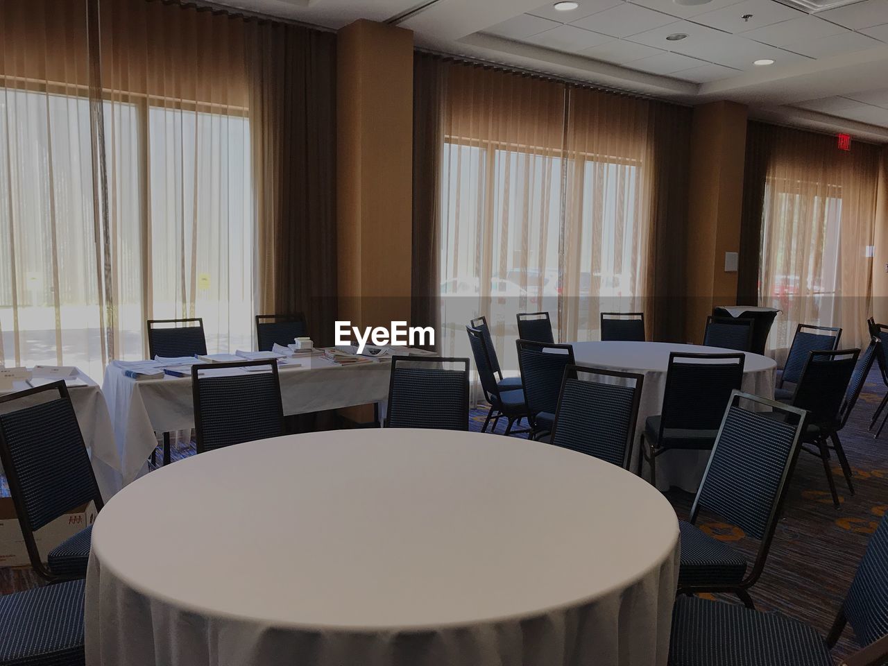 Empty chairs and tables arranged in conference room