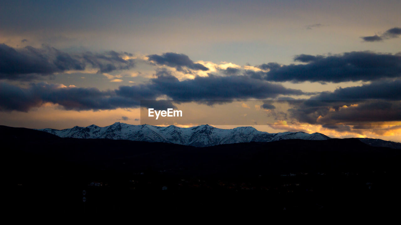 SCENIC VIEW OF SILHOUETTE MOUNTAINS AGAINST CLOUDY SKY