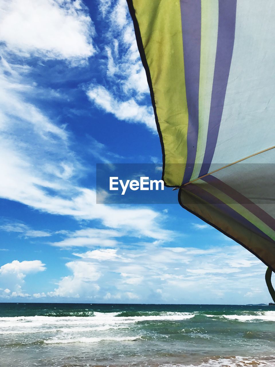 LOW ANGLE VIEW OF BEACH AGAINST BLUE SKY