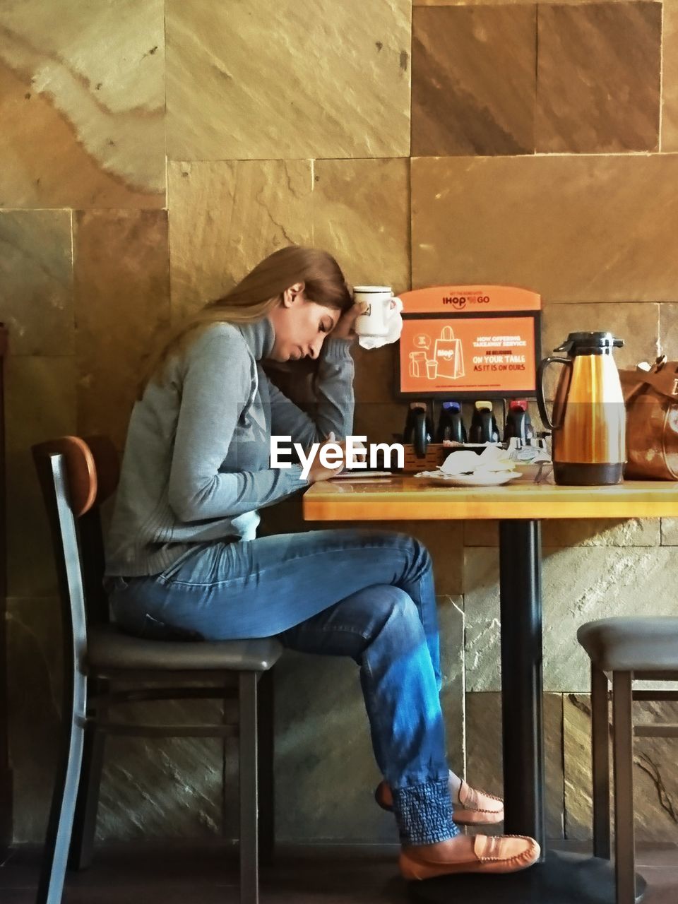 FULL LENGTH OF MAN SITTING ON TABLE IN CAFE