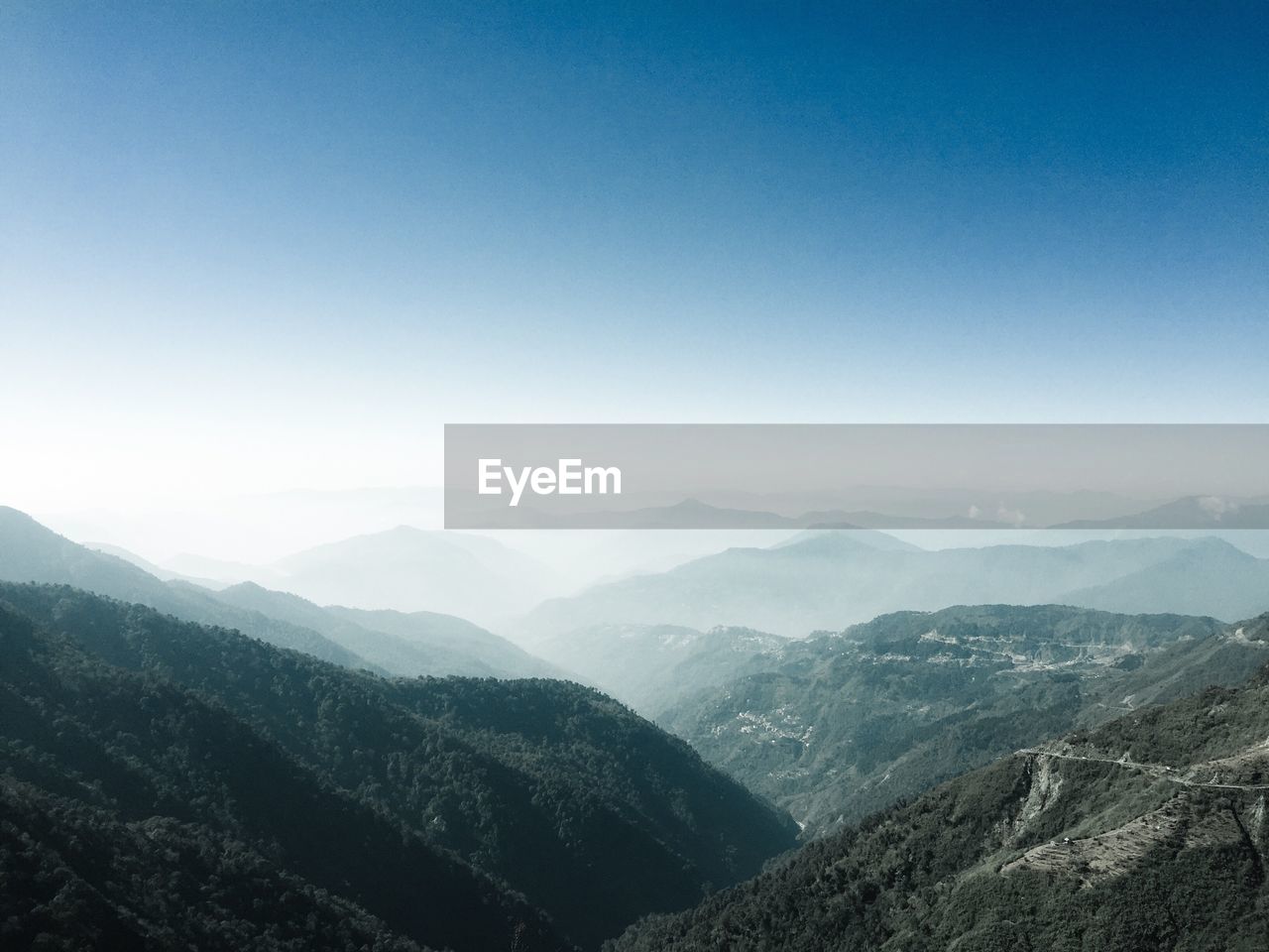 Scenic view of mountains against blue sky