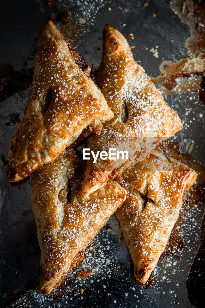 Apple cinnamon baked turnovers on stainless steal pan with sugar