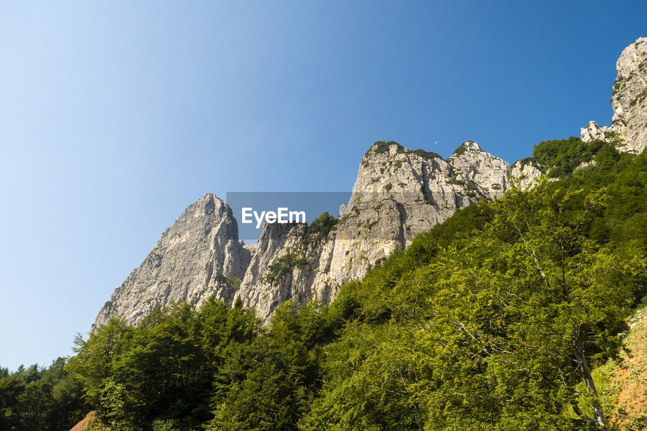 LOW ANGLE VIEW OF ROCK FORMATION AGAINST SKY