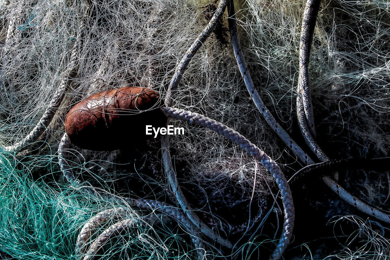 CLOSE-UP OF FISHING NET ON ROPE