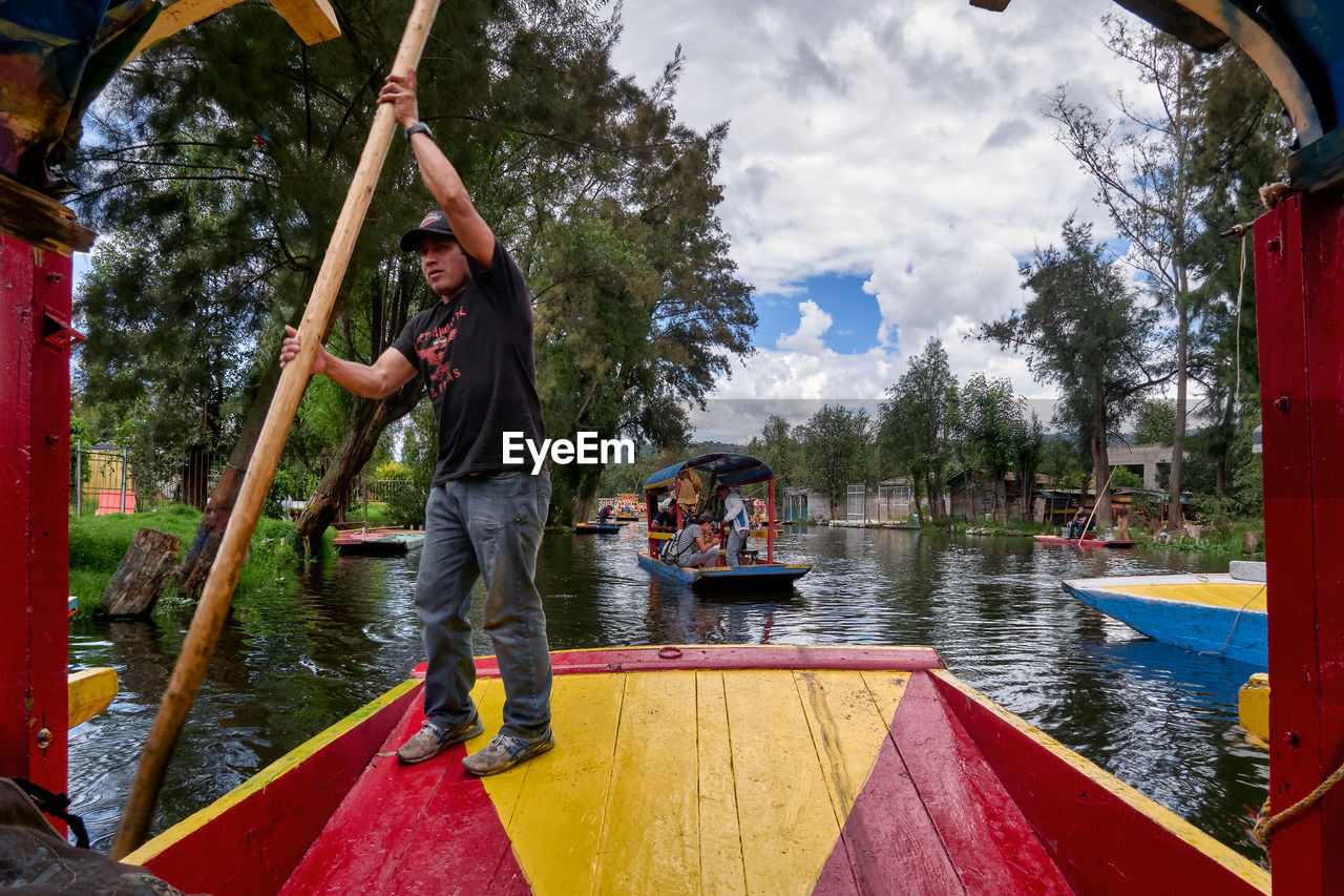 PEOPLE IN BOAT AGAINST LAKE