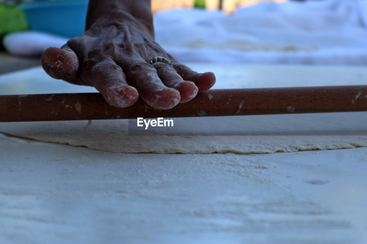 Close-up of woman working on table making turkish traditional food like rolling pizza dough