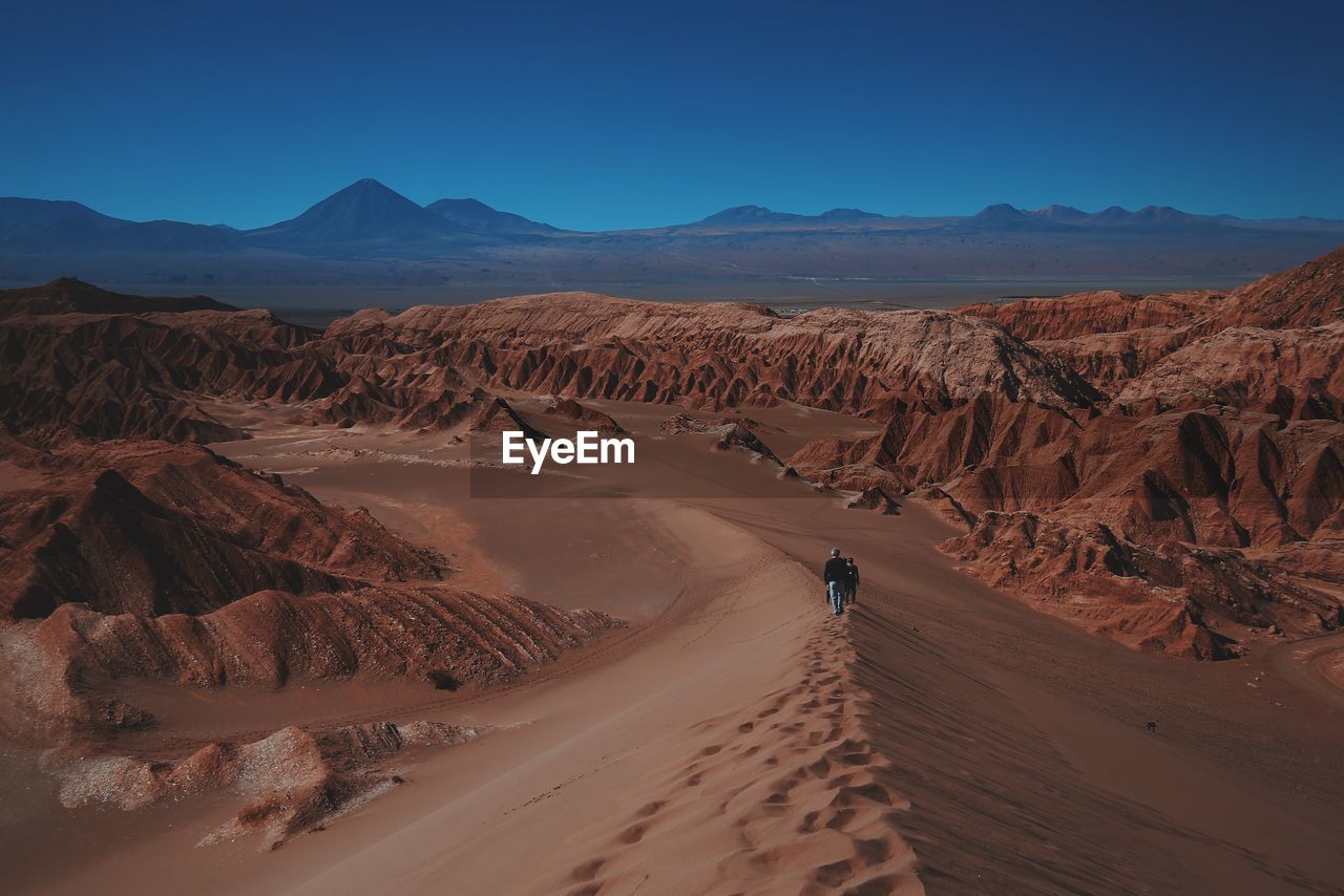 High angle view of people walking on sand