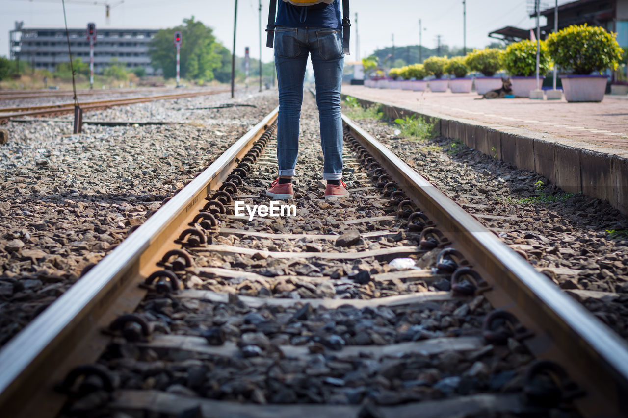 Low section of woman standing on railroad track