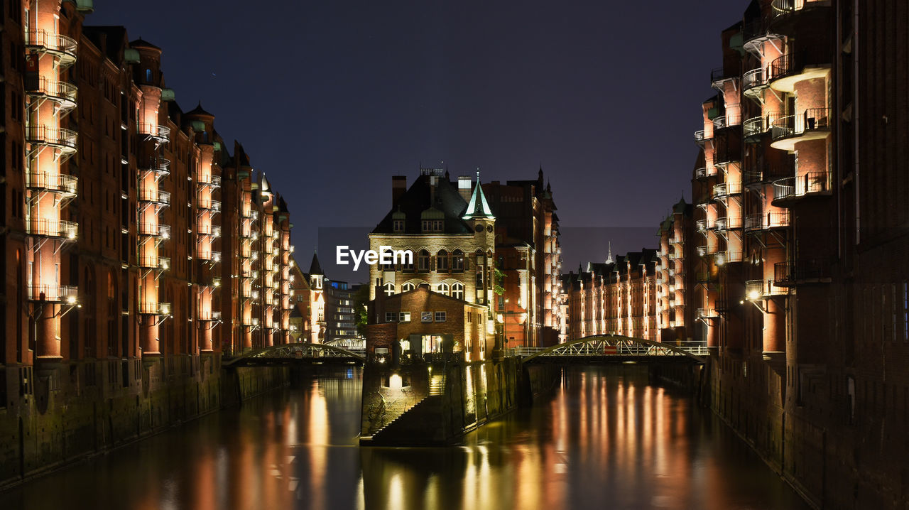 Canal passing through city buildings at night