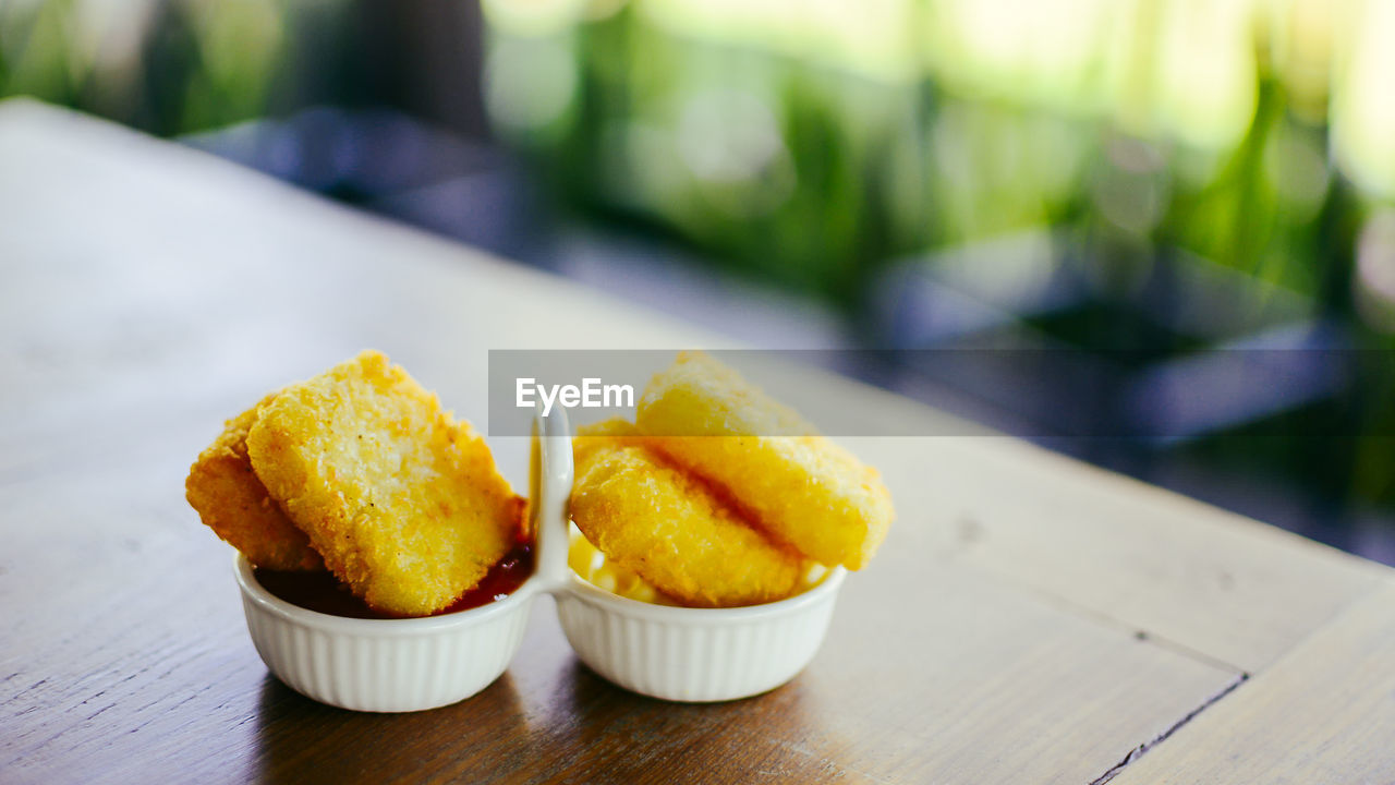 Close-up of fried potatoes in plate containers on table