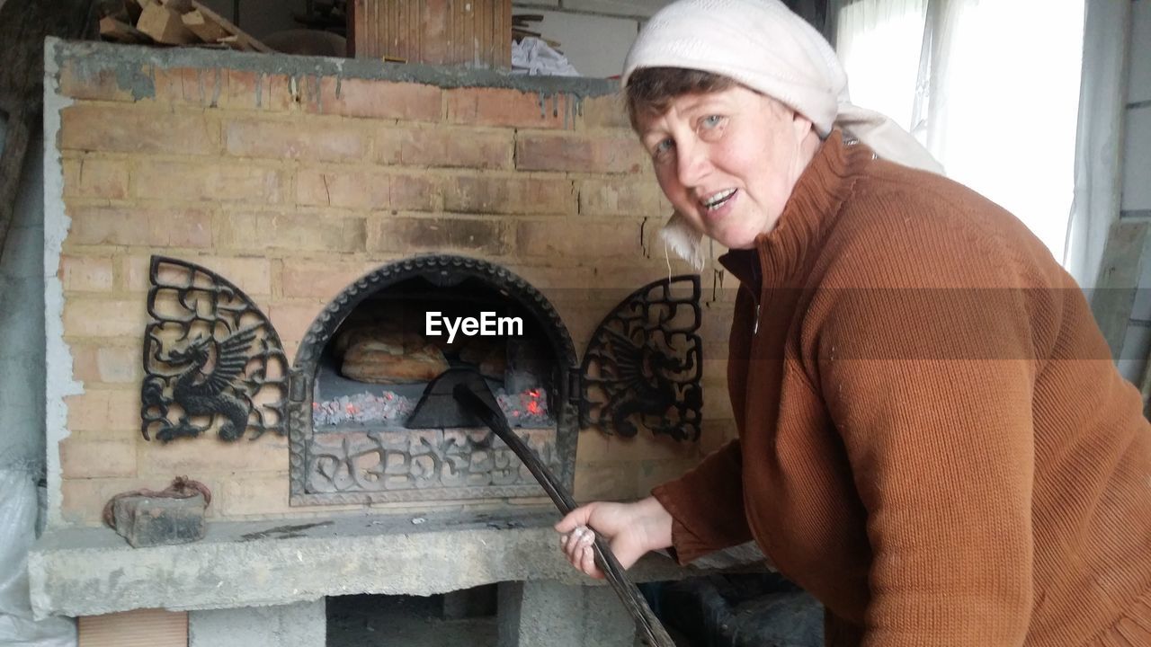 Portrait of woman baking bread in oven