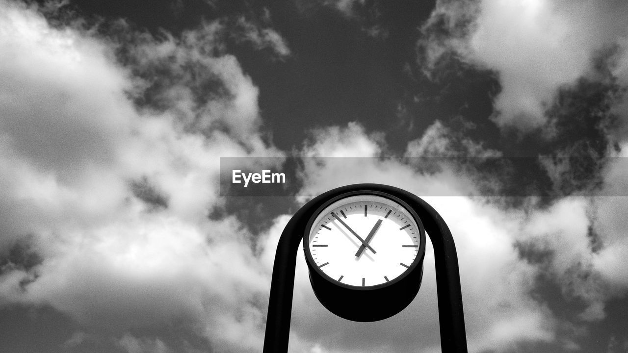 Low angle view of clock against sky