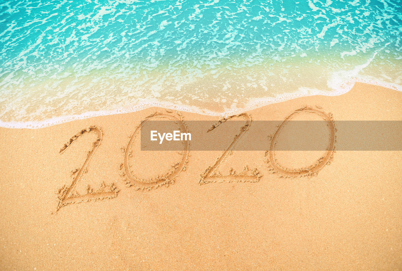 High angle view of numbers on sand at beach