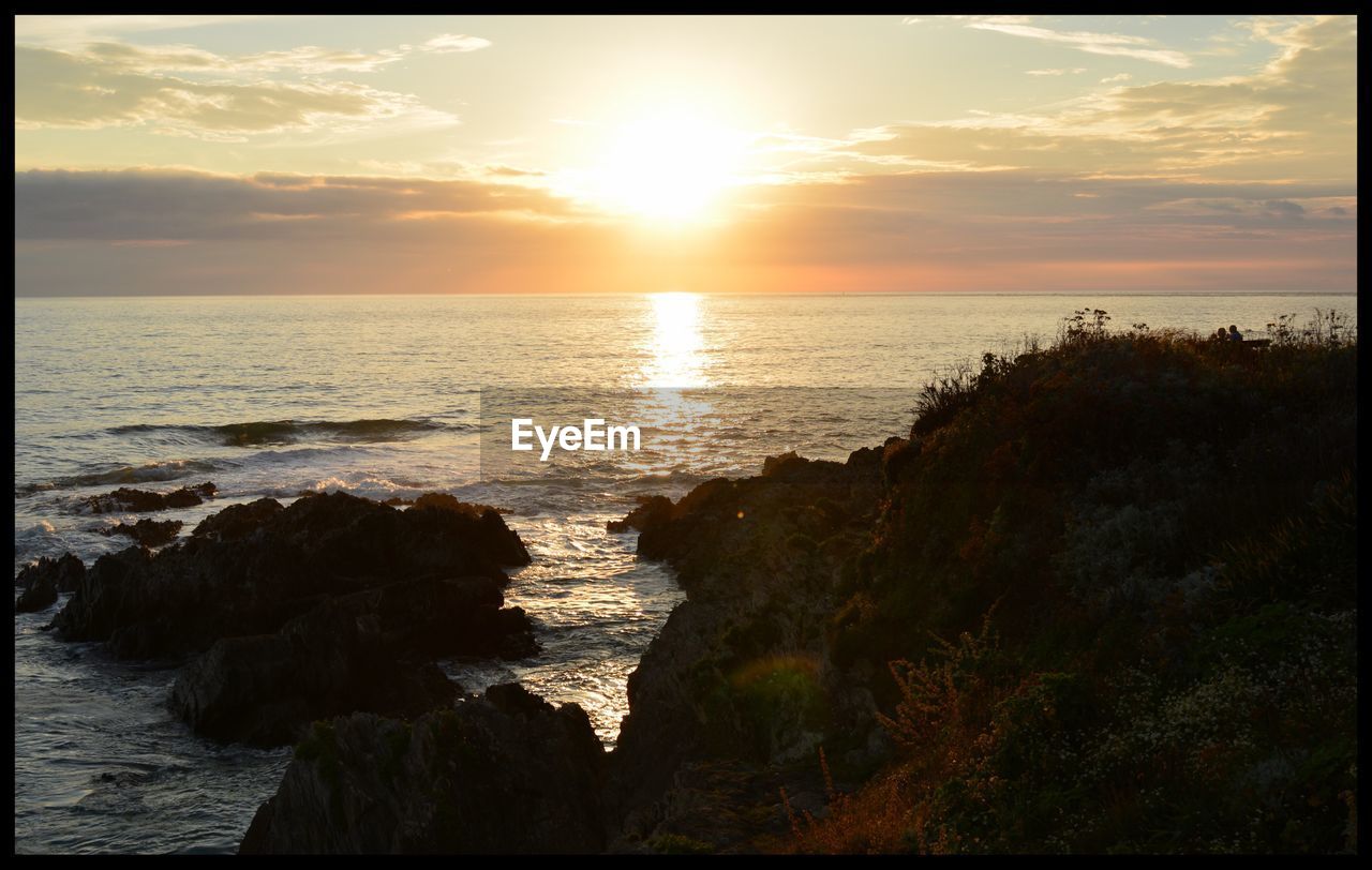 SCENIC VIEW OF BEACH AGAINST SKY DURING SUNSET