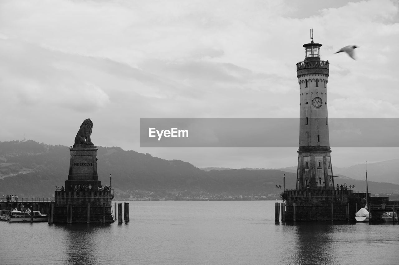 LIGHTHOUSE ON SEA AGAINST BUILDINGS