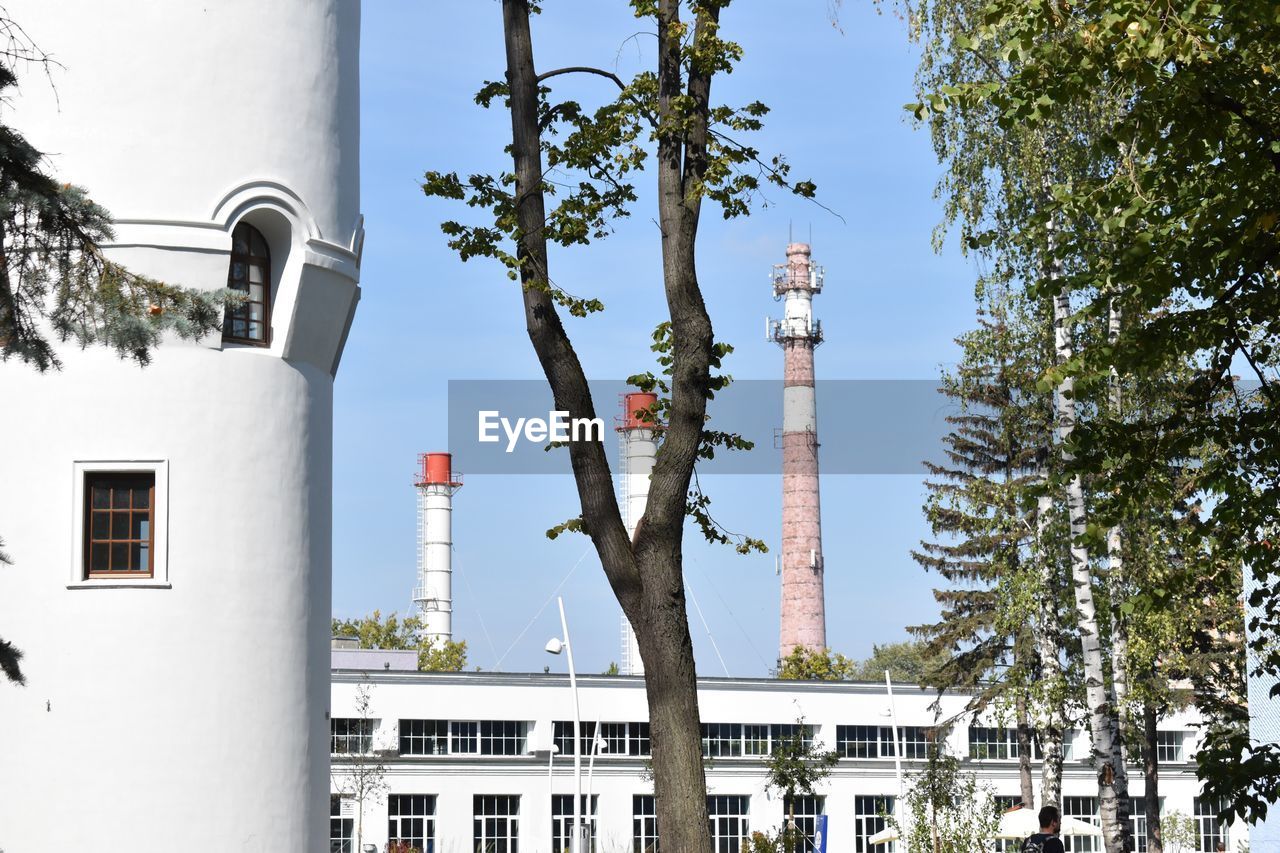 LOW ANGLE VIEW OF BUILDINGS AND TREES AGAINST SKY