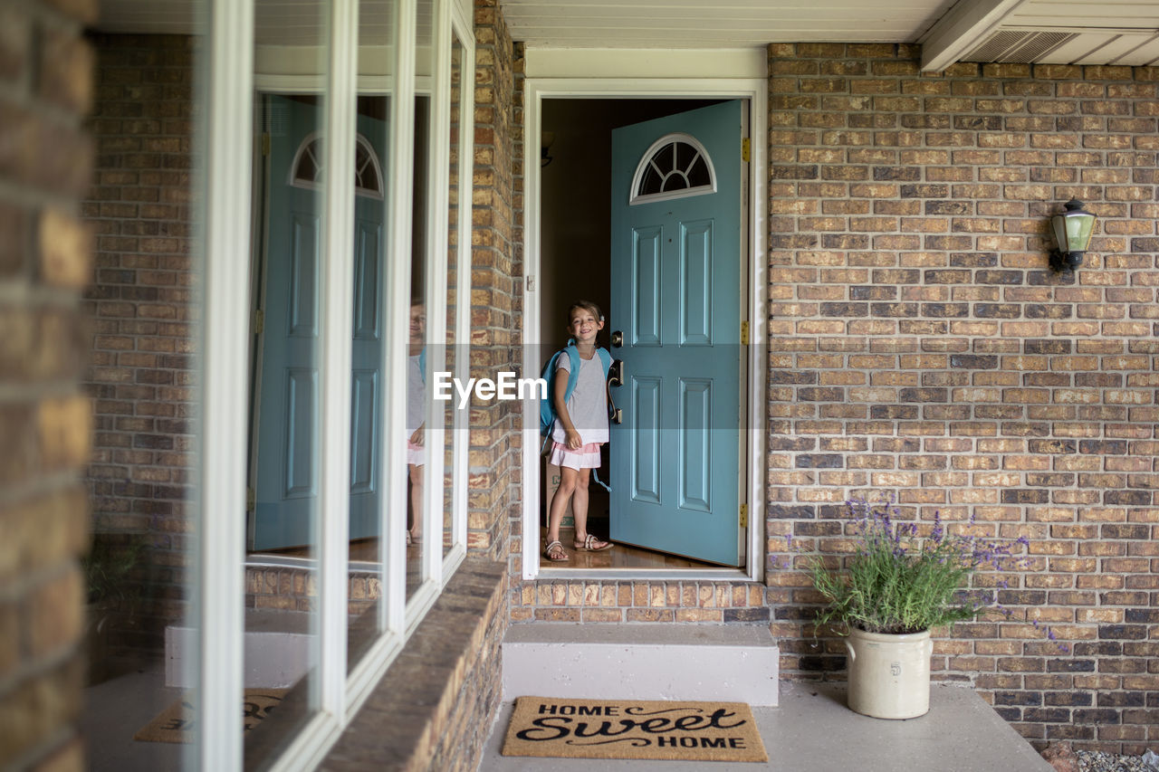 Girl with backpack standing by door