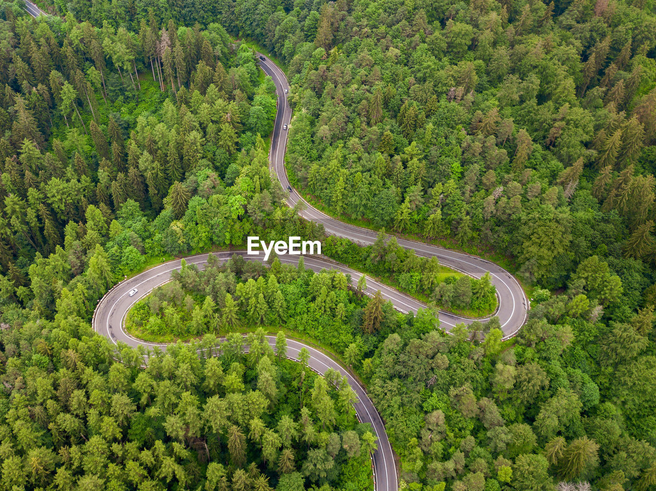Aerial view of countryside road passing through the forest and mountain