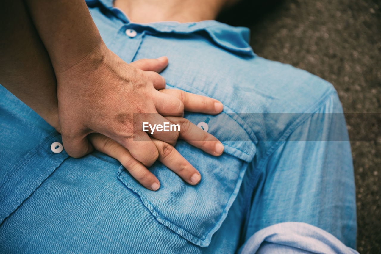 MIDSECTION OF MAN SITTING AT HOME