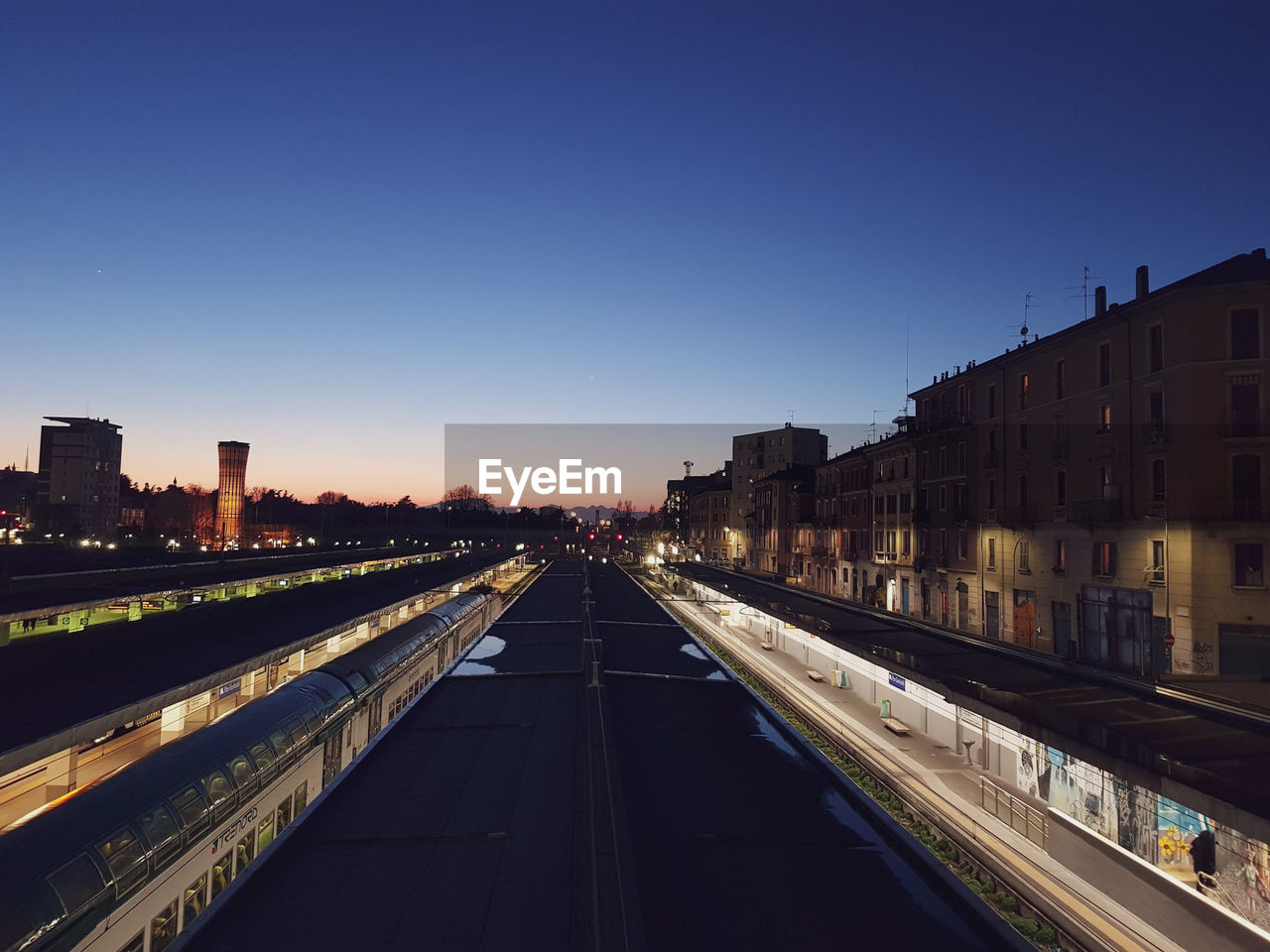 ILLUMINATED CITY BUILDINGS AGAINST CLEAR SKY