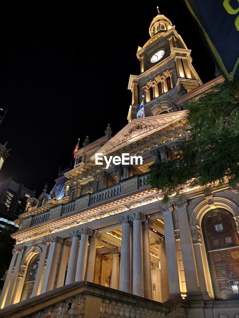 LOW ANGLE VIEW OF ILLUMINATED BUILDINGS AGAINST SKY AT NIGHT