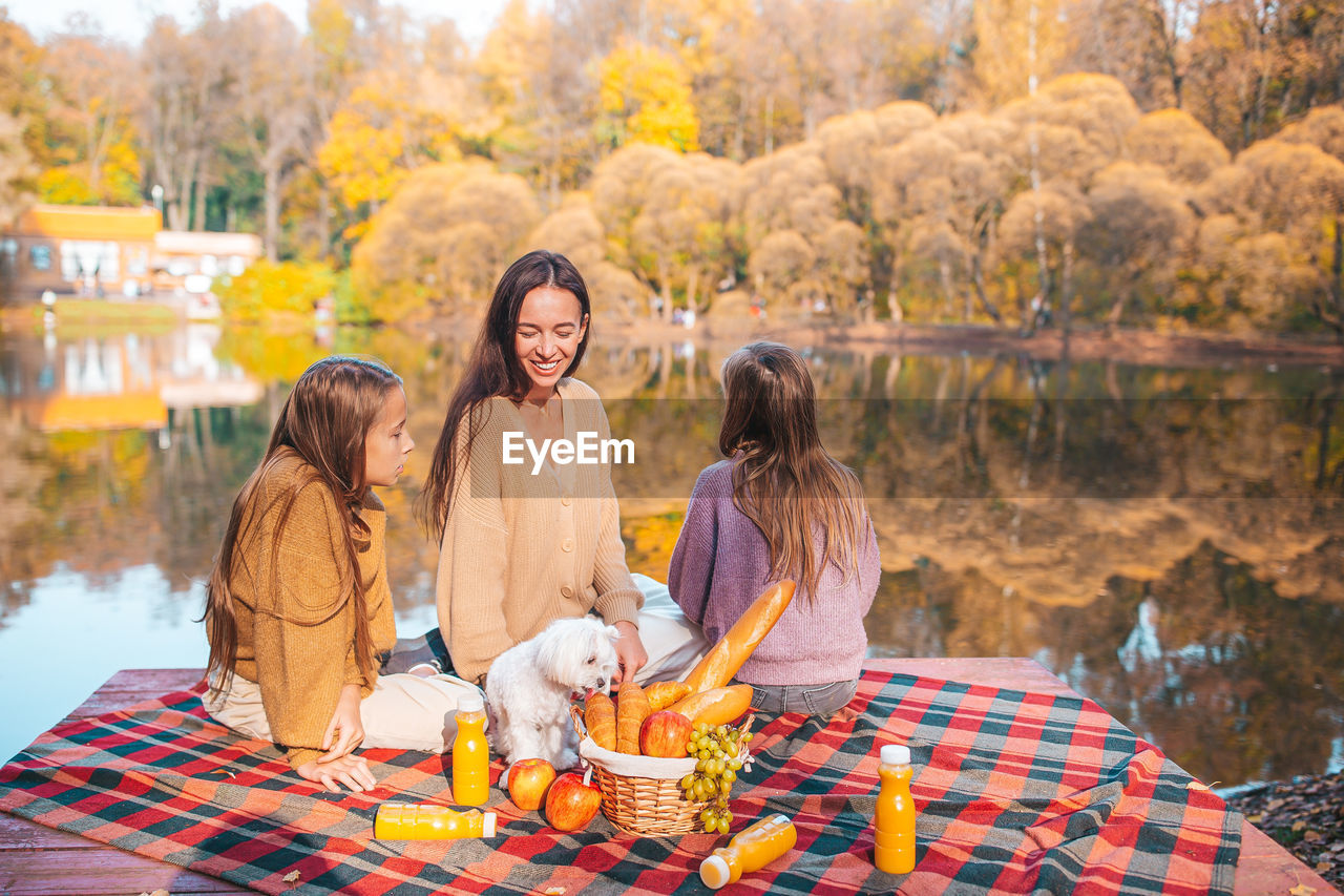 GROUP OF PEOPLE SITTING IN FRONT OF AUTUMN