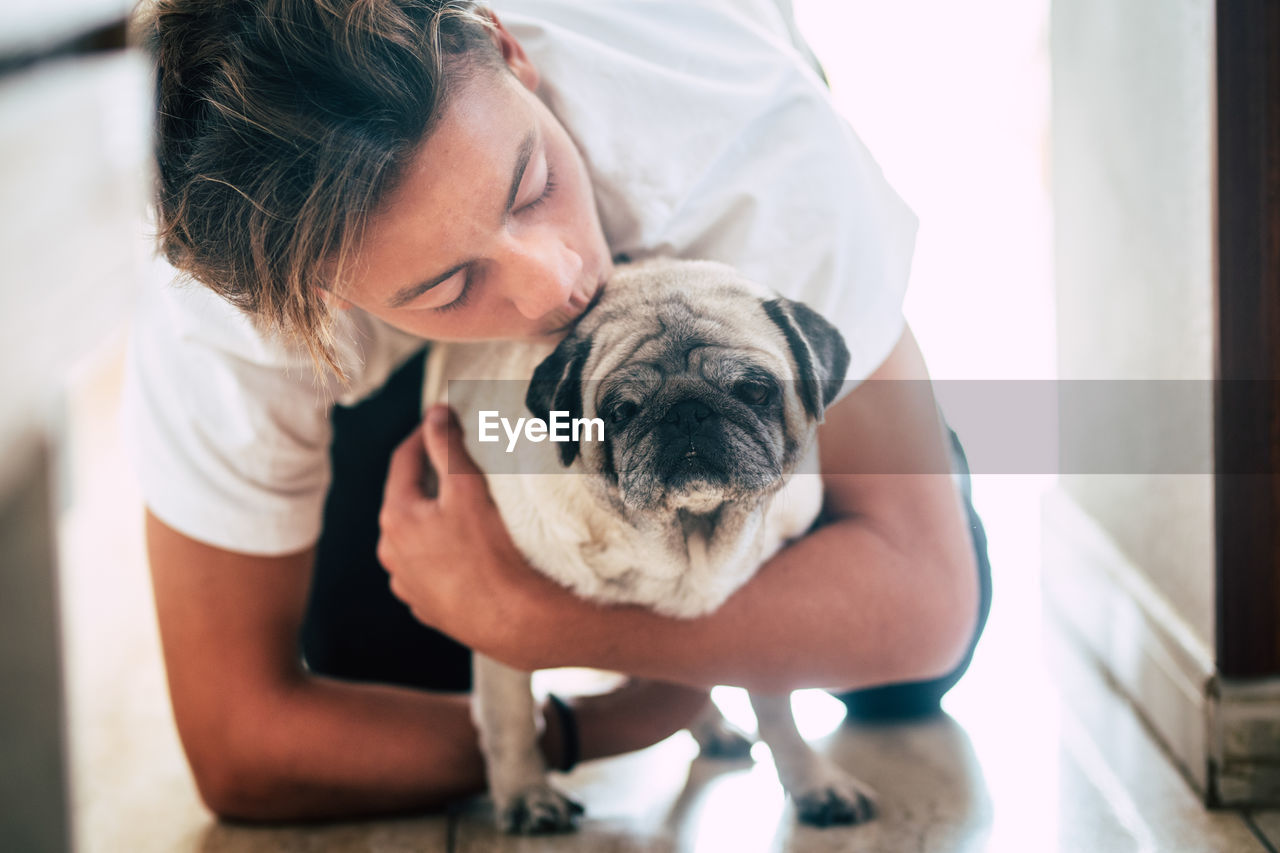 Boy kissing dog at home