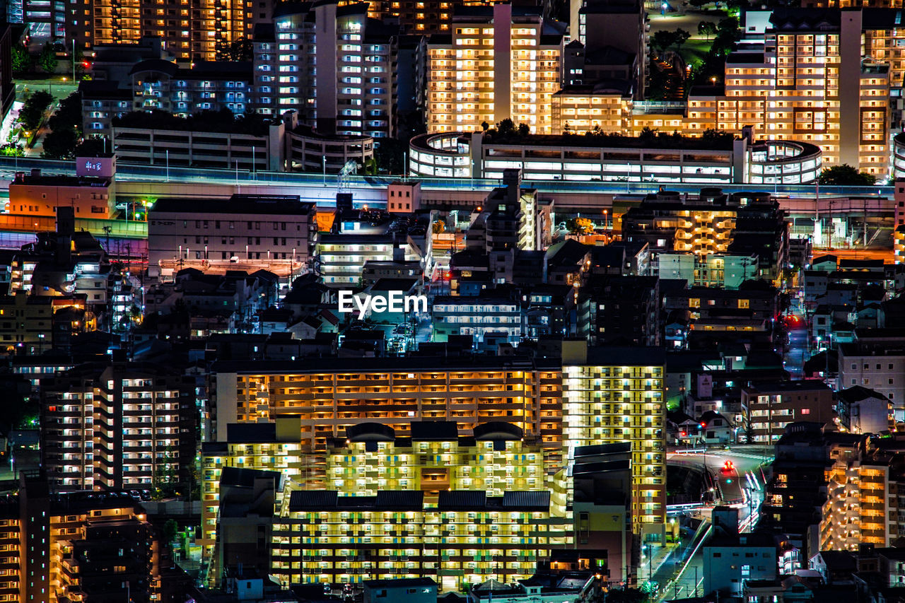 high angle view of illuminated buildings in city at night