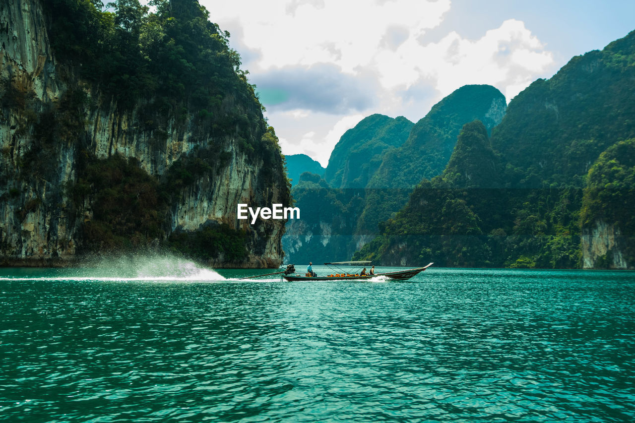 Scenic view of sea and mountains against sky