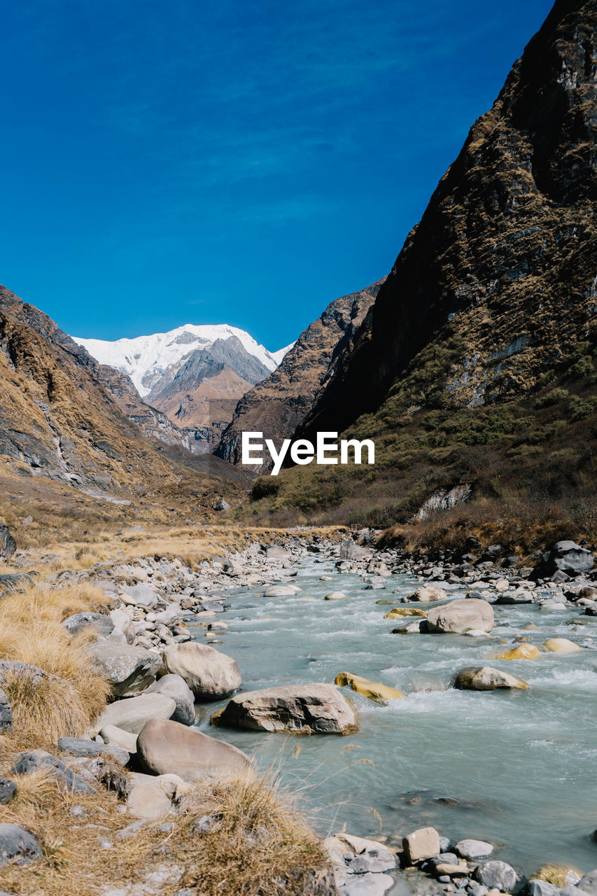 Scenic view of mountains against blue sky