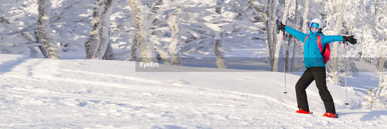 rear view of man skiing on snow covered field