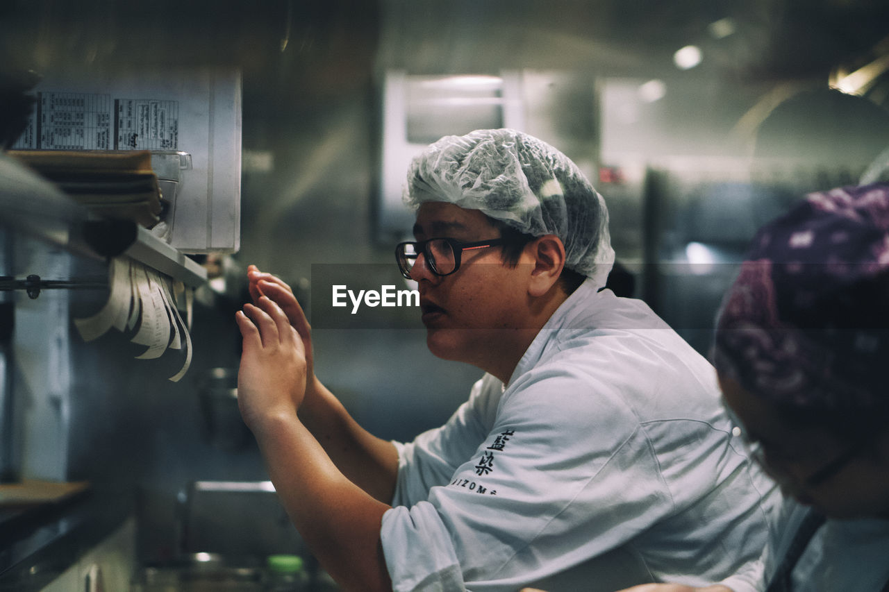 SIDE VIEW OF A MAN WORKING AT OFFICE