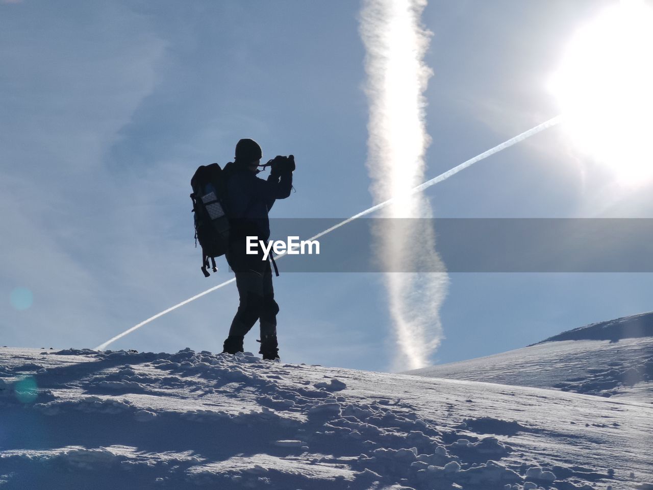 Low angle view of man standing on snow against sky