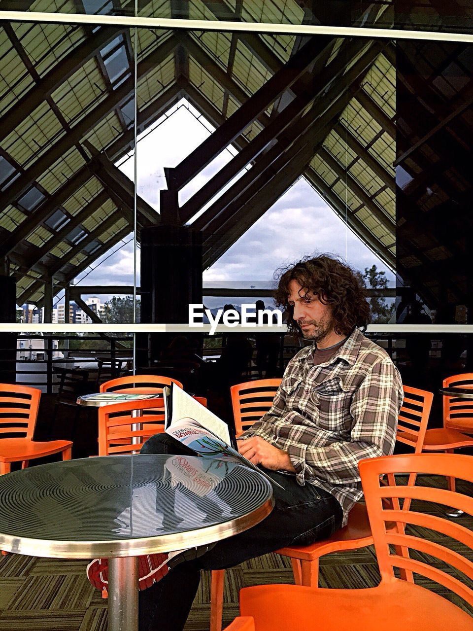 PORTRAIT OF MAN SITTING ON TABLE IN CAFE