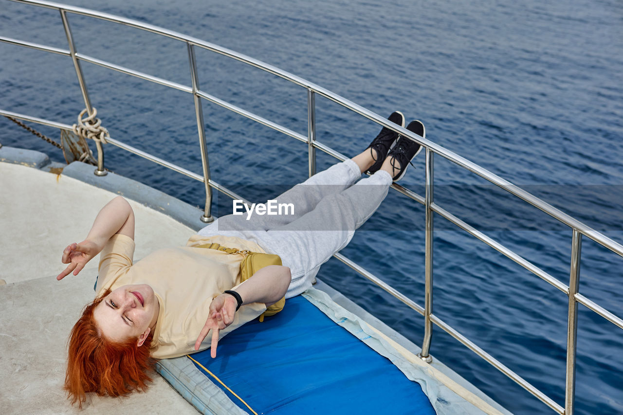 Woman lying on boat in sea