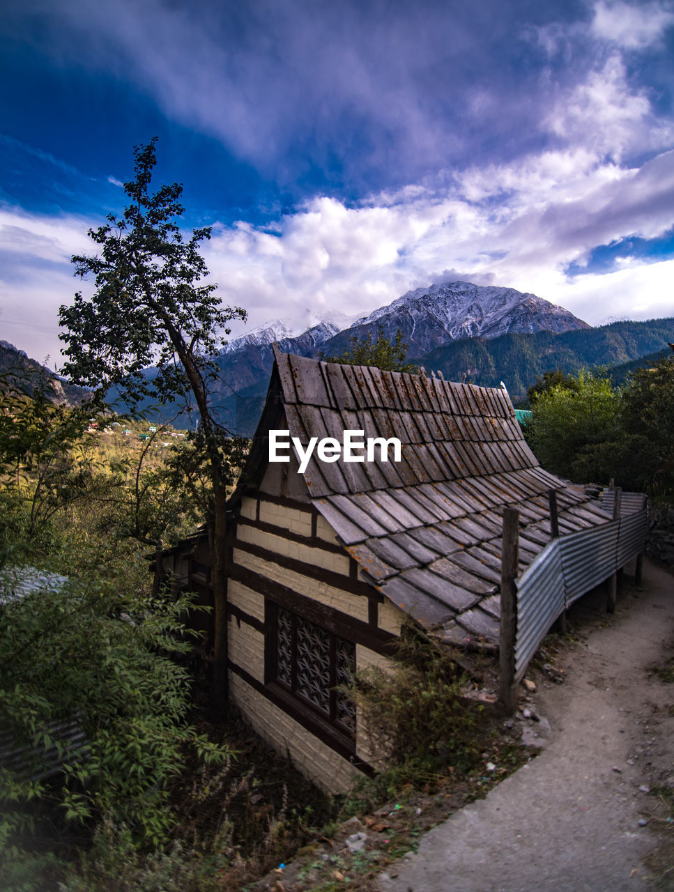 architecture, sky, cloud, mountain, built structure, building, environment, nature, landscape, building exterior, house, tree, plant, mountain range, scenics - nature, travel destinations, no people, beauty in nature, travel, land, rural area, residential district, outdoors, roof, tourism, history, wilderness, rural scene, village, the past, forest