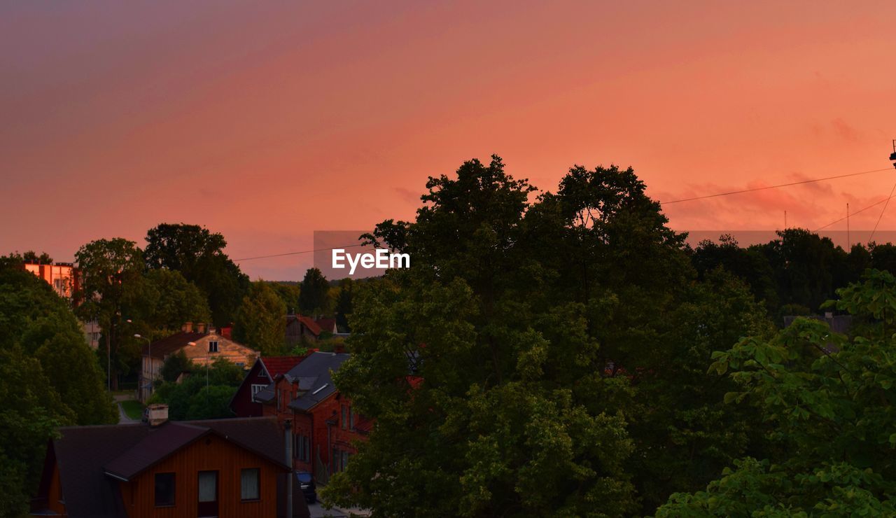 HOUSES AND TREES AGAINST SKY DURING SUNSET