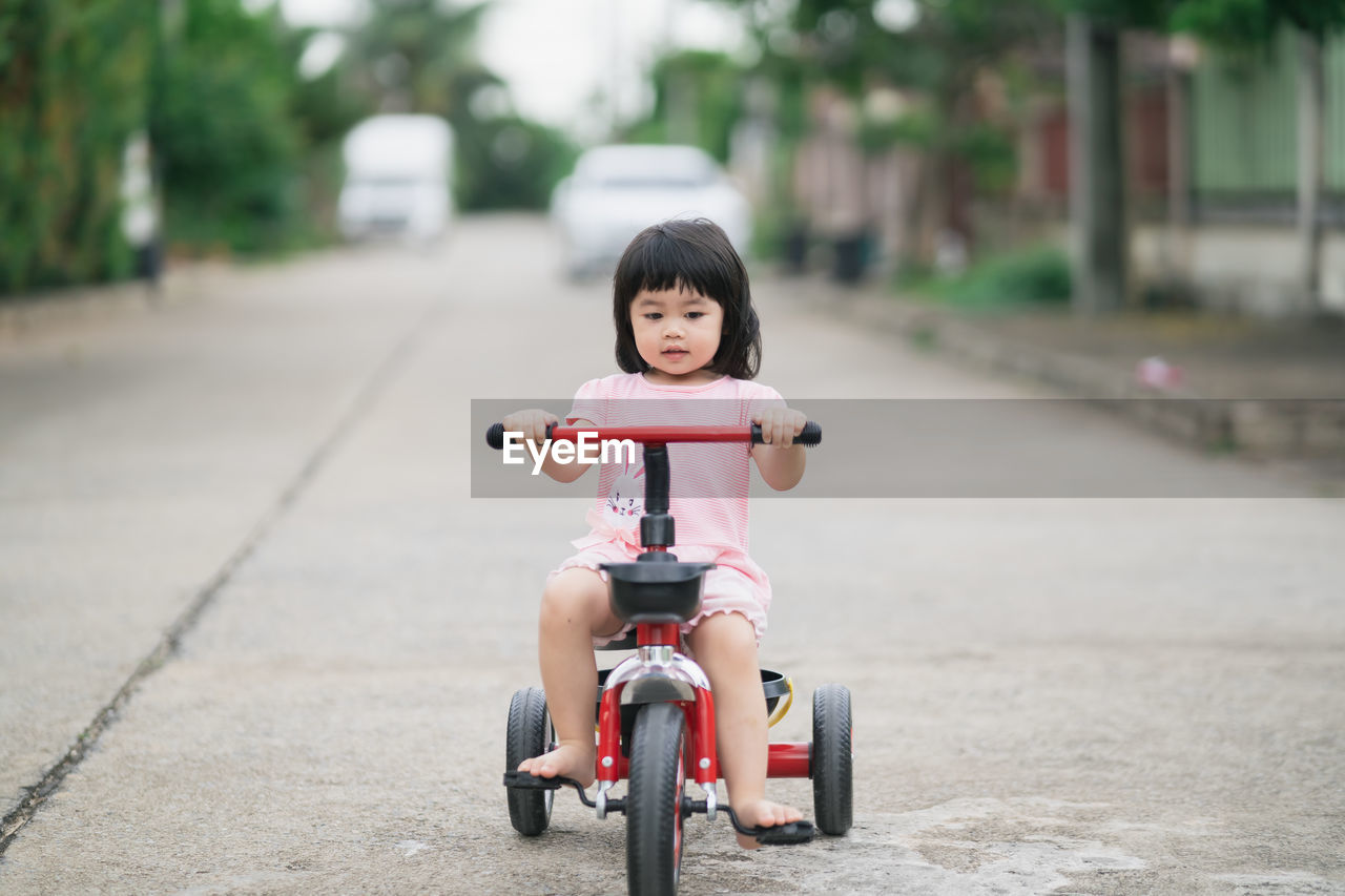 Portrait of cute boy riding toy car