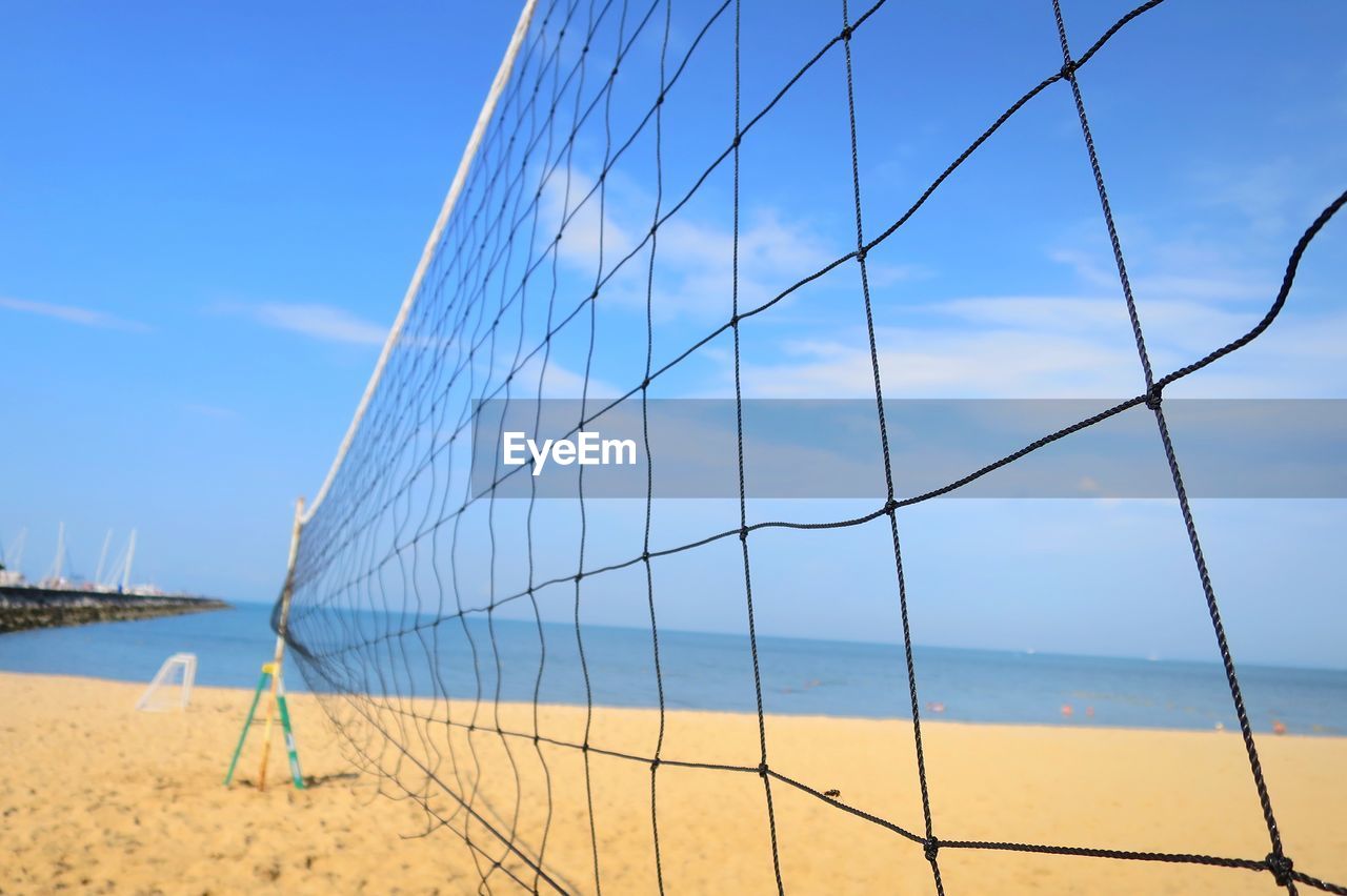 Close up of volleyball net with sea beach and blue sky in summer.