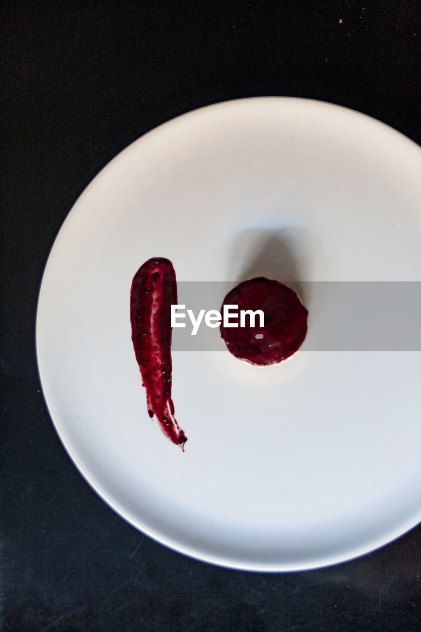 red, food and drink, plate, food, indoors, no people, freshness, directly above, high angle view, black background, sweet food, studio shot, petal, produce, close-up, lip