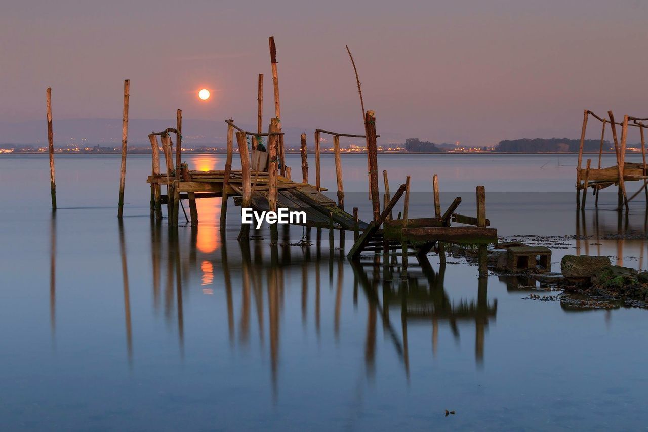 Piers on sea at sunset